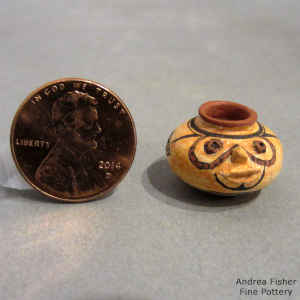 Fish, face and geometric design on a miniature polychrome jar