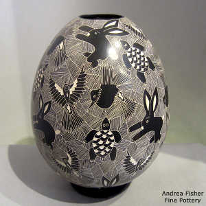 Sgraffito animal and geometric design on a black and white jar