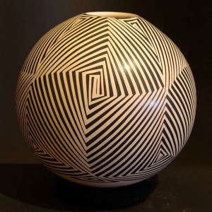 An angular spiral design on a black on beige jar