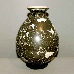Sgraffito cow and geometric design on a black and white jar