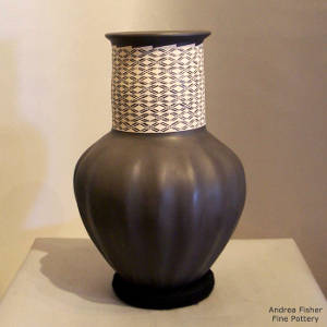 White geometric hatching around the long neck of a black melon jar