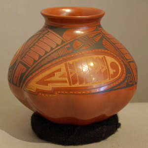 Sgraffito and painted geometric design on a polychrome red jar with melon-shaped base