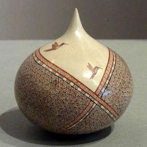 Geometric and hummingbird designs on a polychrome tear drop sculptural piece