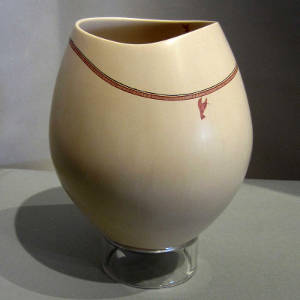 Fine line geometric necklace plus hummingbird on a tan jar with an organic opening