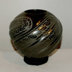 Geometric design on a black on black swirl-ribbed melon jar