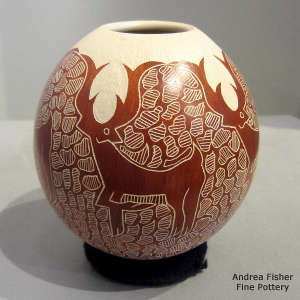 An organic opening on a red and white jar with a sgraffito deer, snow and mesh design
