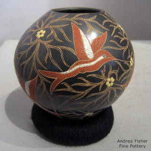 Sgraffito and painted hummingbird and tree branch design on a polychrome jar