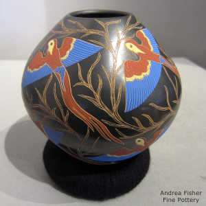 Sgraffito and painted parrot and branch design on a poychrome jar
