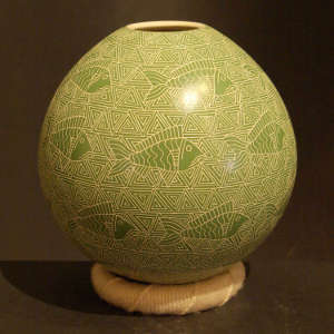 Sgraffito fish and geometric design on a green on beige jar