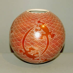 Sgraffito lizard and net design on a red jar