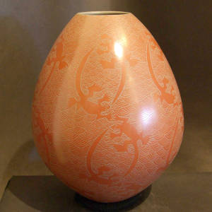 Sgraffito lizard and web design on a red jar