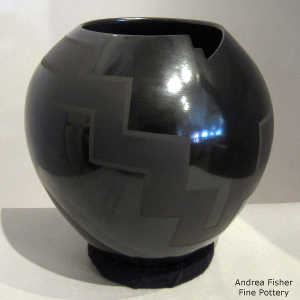 Geometric cut opening and geometric design on a black on black jar