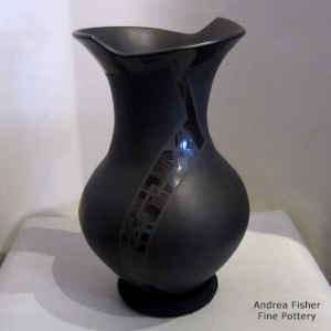 Black on black on black vase with a geometric design and an organic opening