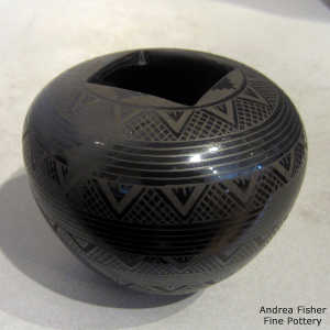 Geometric design on a black on black jar with a square opening