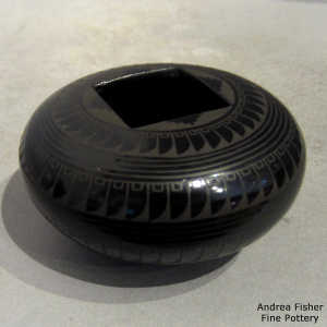 Bands of geometric design on a ablack on black jar