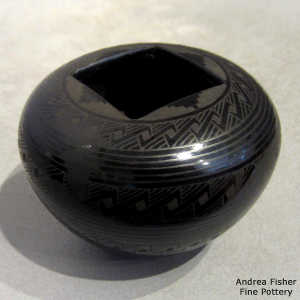 Bands of geometric design on a black on black jar with a square opening