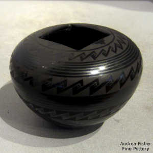 Bands of geometric designs on a black on black jar with a square opening