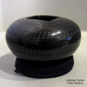 Square opening and geometric design on a black on black jar