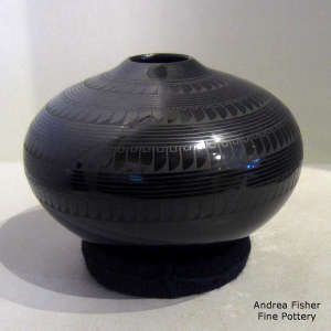 Bands of geometric design on a black on black jar with a square opening