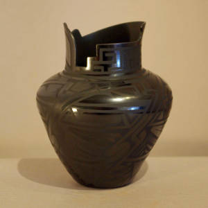 Paquime geometric designs decorate a black on black jar with an organic opening