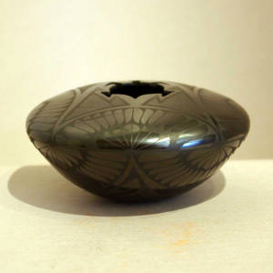 Paquime feather and geometric designs on a black on black jar with a turtle-shaped opening