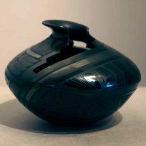 Geometric design and a stylized step and lightning bolt opening on a black on black jar