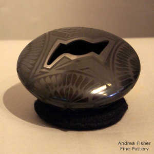 Geometric designs on a black on black jar with a stylized bat opening