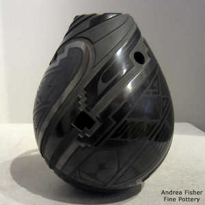 Geometric cutouts and design on a black on black on black jar