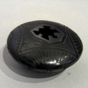 Geometric designs on a black on black jar with a geometric cut opening