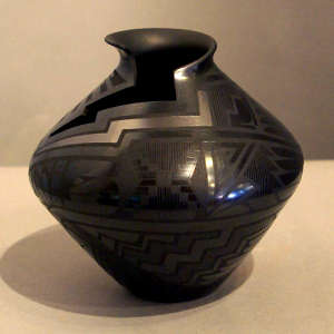 Geometric cutouts and design on a black on black jar