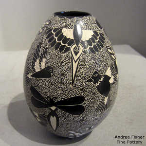 Sgraffito dragonfly, butterfly, bird and mesh design on a black and white jar