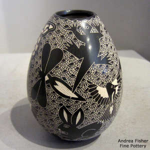 Sgraffito insect and animal motif on a black and white jar