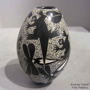 Sgraffito animal, reptile, bird, insect and mesh geometric design on a black and white jar
