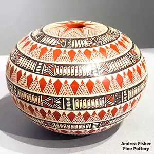 A geometric desifgn etched and painted on a polychrome seed pot