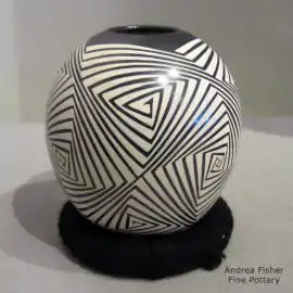 Cream geometric design on a glossy black jar