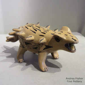 Geometric design in black on a yellow dinosaur figure