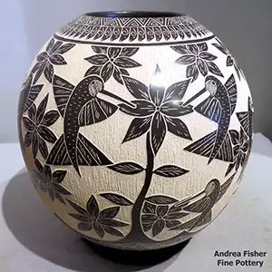 A sgraffito hummingbird, flower and geometric design on a black-and-white jar