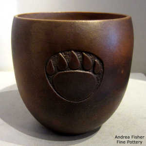 Fire clouds on a brown micaceous jar with a sgraffito bear paw design