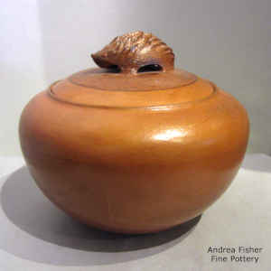 Golden micaceous jar with a hedgehog handle on the lid