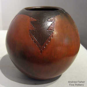 Arrowhead and geometric design on a brown jar with fire clouds
