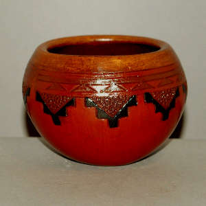 Navajo carpet design around a small brown bowl