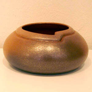 Decorative rim around the organic opening on a golden micaceous jar