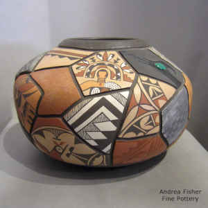 A carved and painted selection of designs from different pueblos on a polychrome shard pot