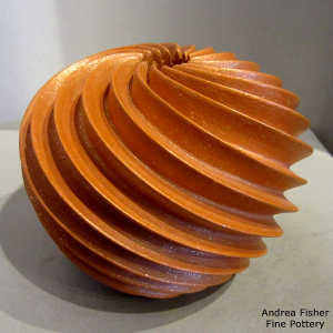 Deep carved spiral design on a golden micaceous seed pot