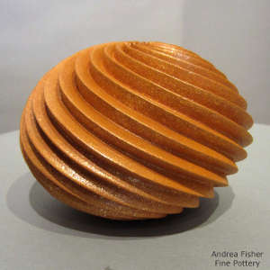 Spiral design carved deep into an orange micaceous pot