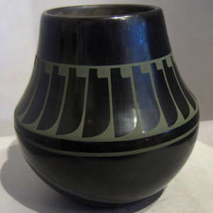 Green slip feather design on a black water jar