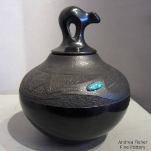 Avanyu design carved into a lidded black jar with a micaceous slip