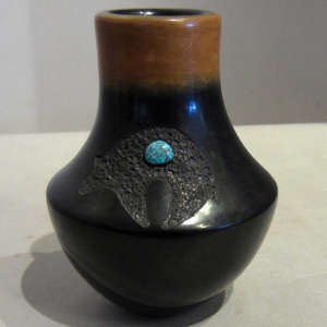 Sgraffito bear design and inlaid turquoise on a tall necked black jar with sienna rim