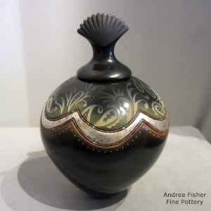 A sgraffito geometric design and inlaid strands of heishe beads on a lidded polychrome jar