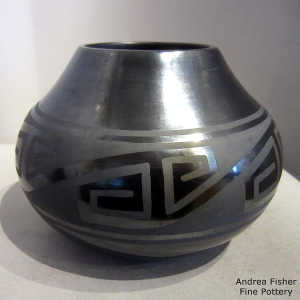 An interlocking geometric design on a black on gunmetal black jar